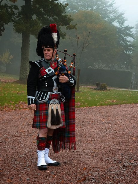 Piper in Maclean Tartan